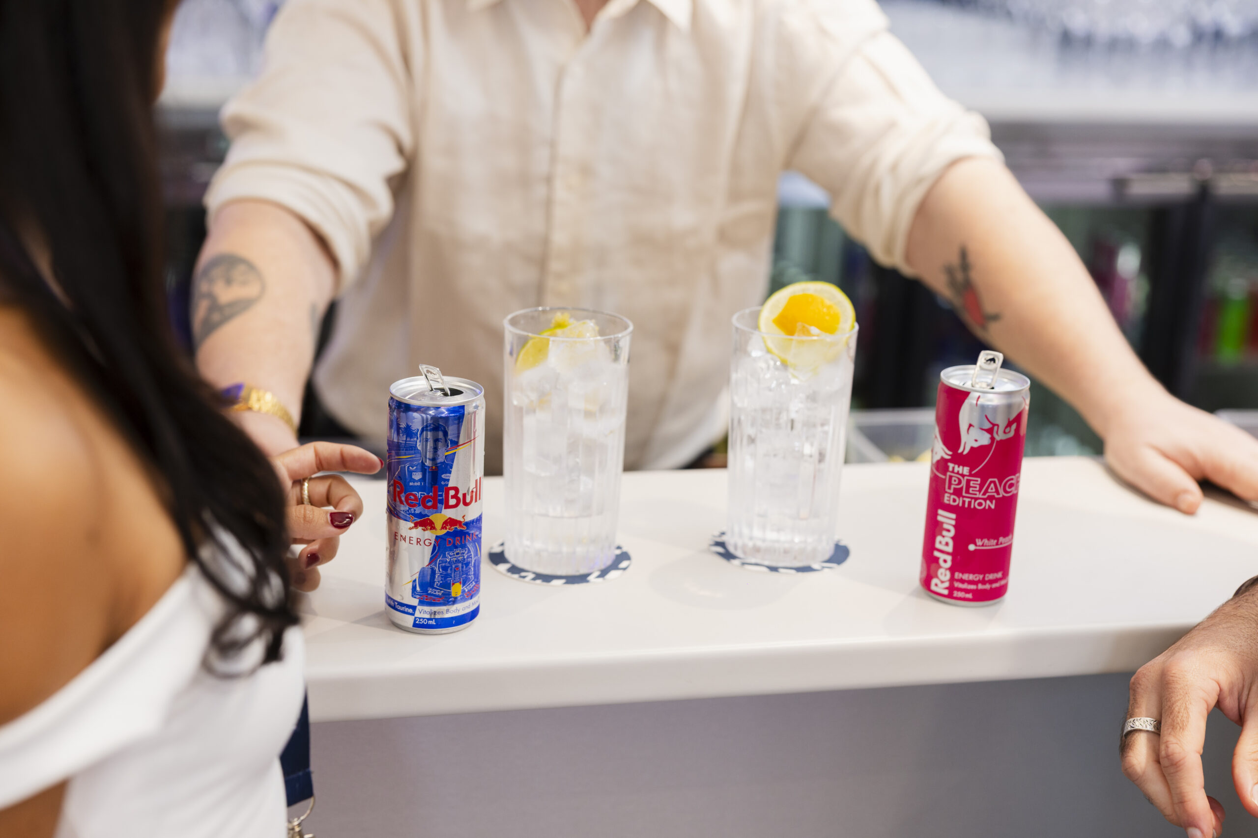 Sweet&Chilli bartender serving two Red Bull cocktails to guests