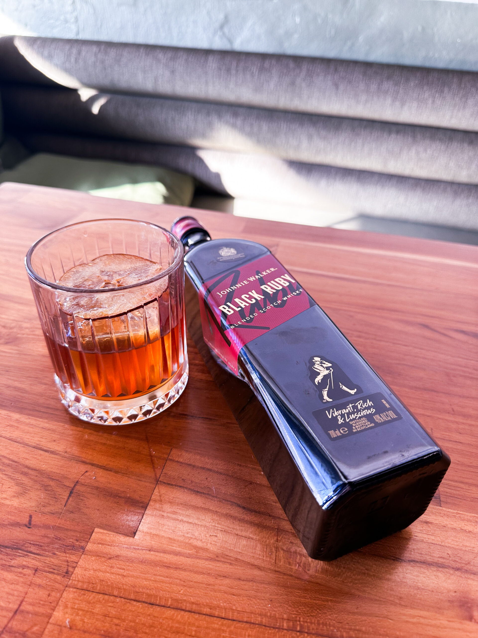 Johnnie Walker Black Ruby cocktail and bottle on wooden table